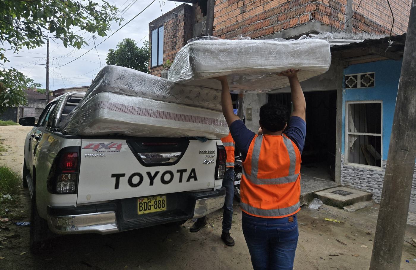Personal de GAMMA cargando colchones en la camioneta