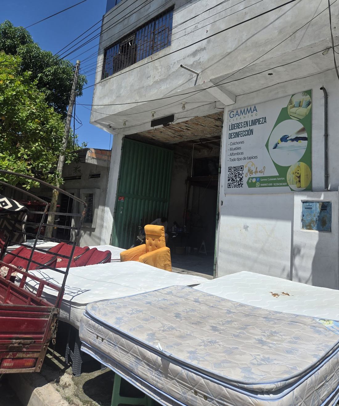 Fachada de la planta de GAMMA Cleaning en Iquitos con colchones y muebles en proceso