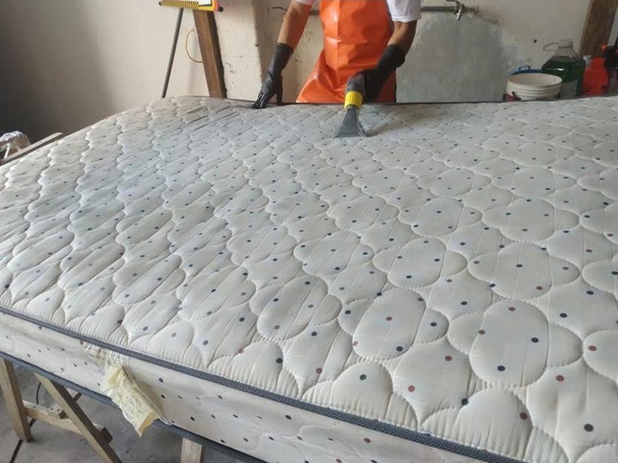 Operario lavando un colchón con equipo de inyección y extracción