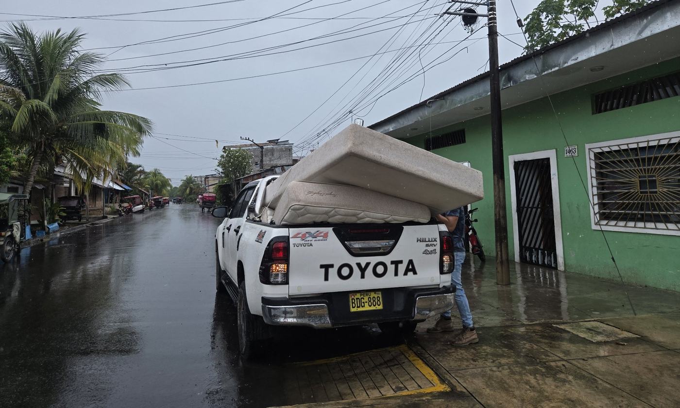 Camioneta de GAMMA con colchones durante el recojo, en día de lluvia